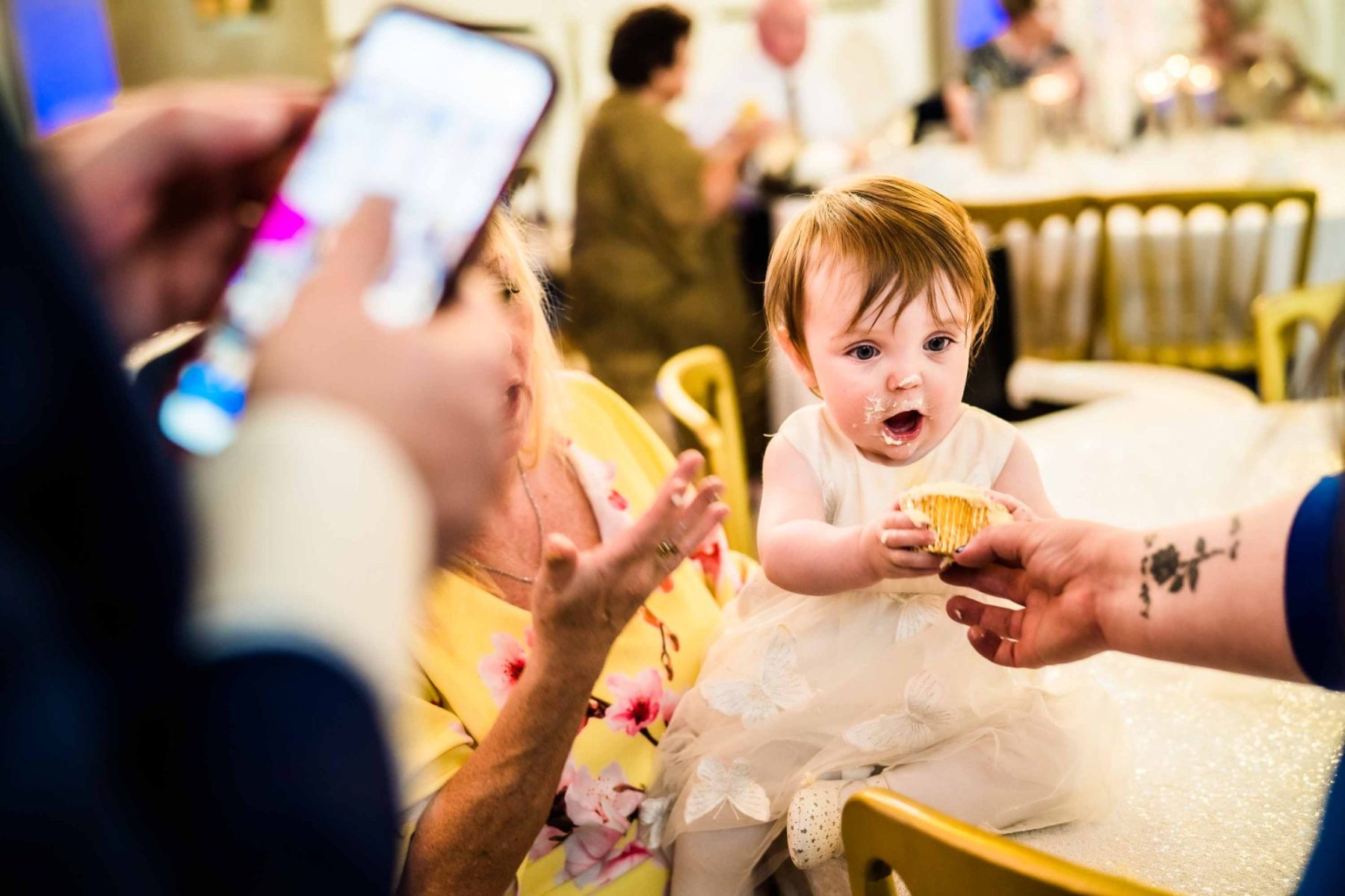 Baby looking surprised with wedding cupcake