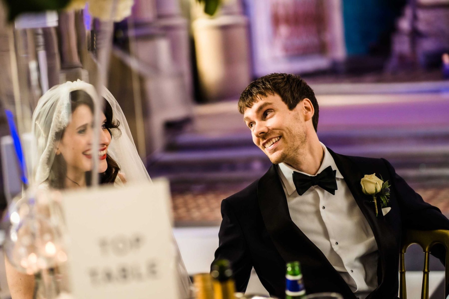Bride and groom smiling at each other during speeches Gorton Monastery Wedding