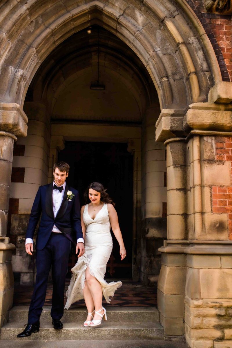 Bride and groom walking down the steps at Manchester Monastery