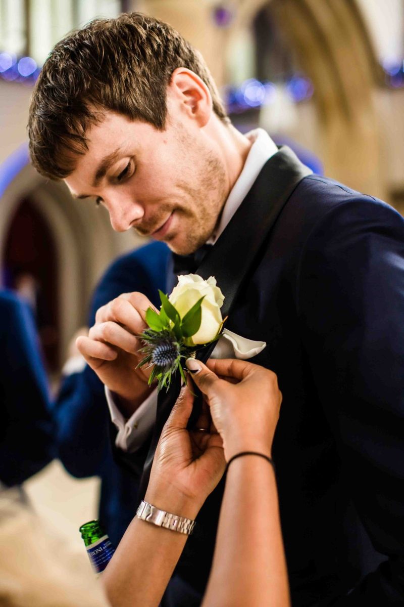 Groom having his buttonhole pinned on