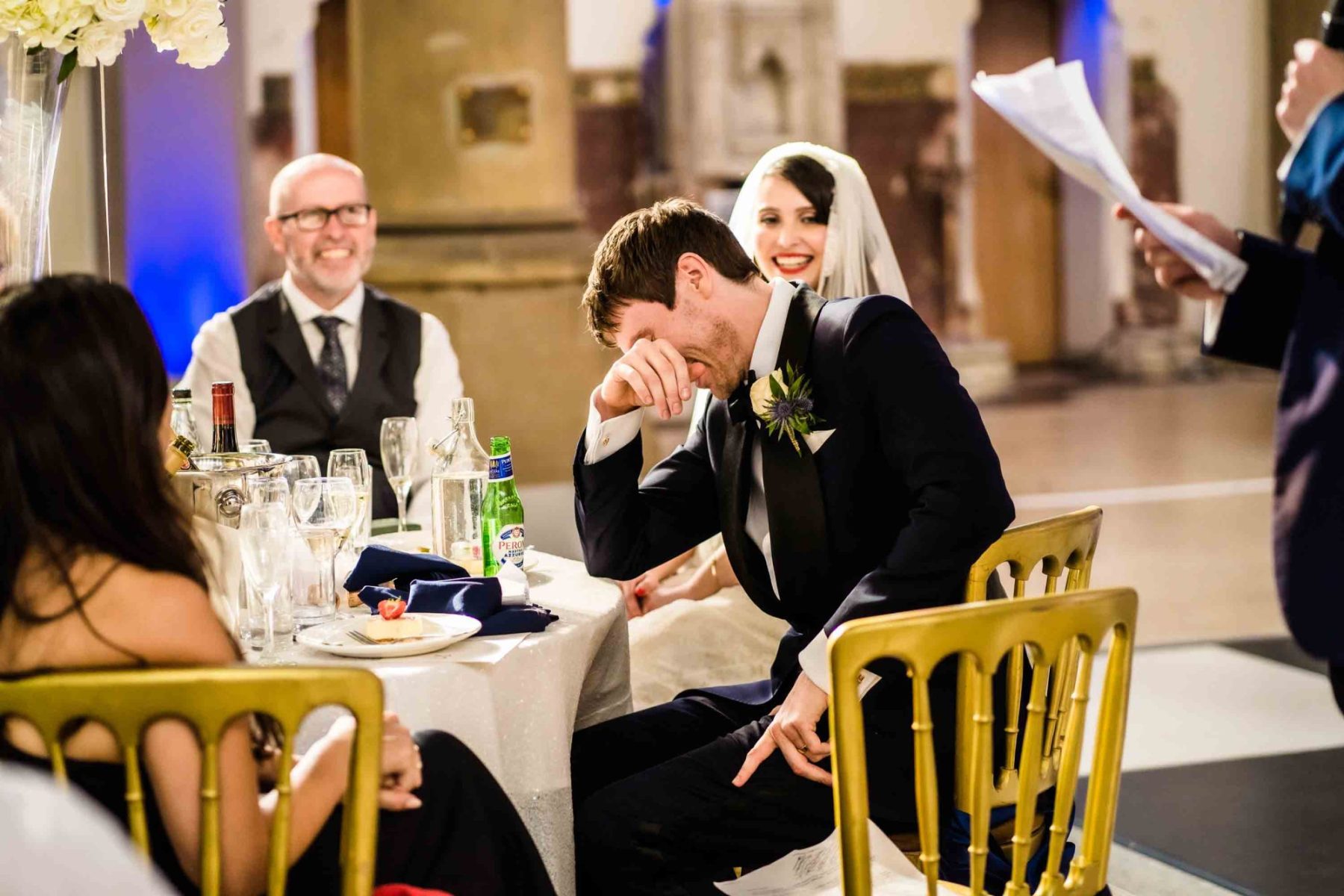Groom with head in hands during speeches at Gorton Monastery Wedding