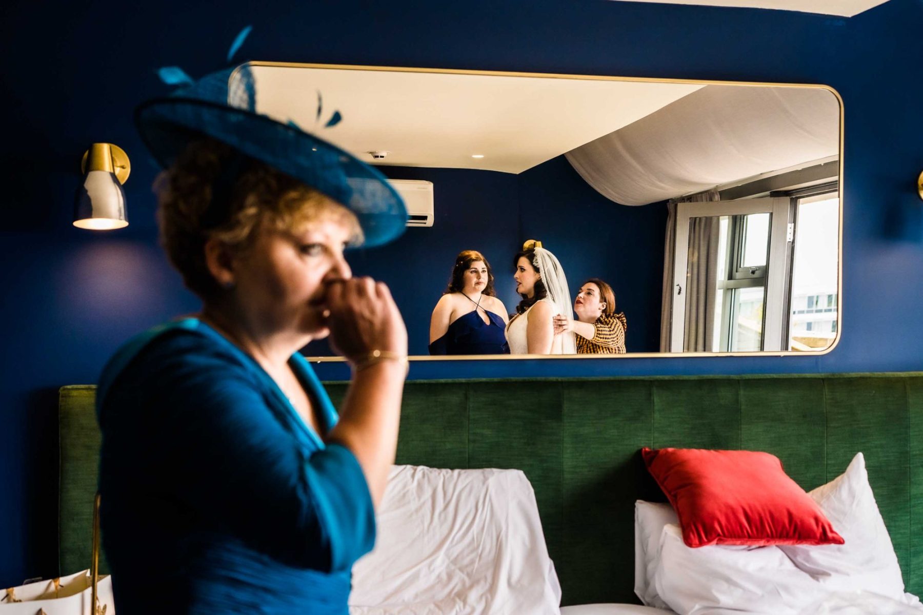 Mum crying in foreground watching bride get ready