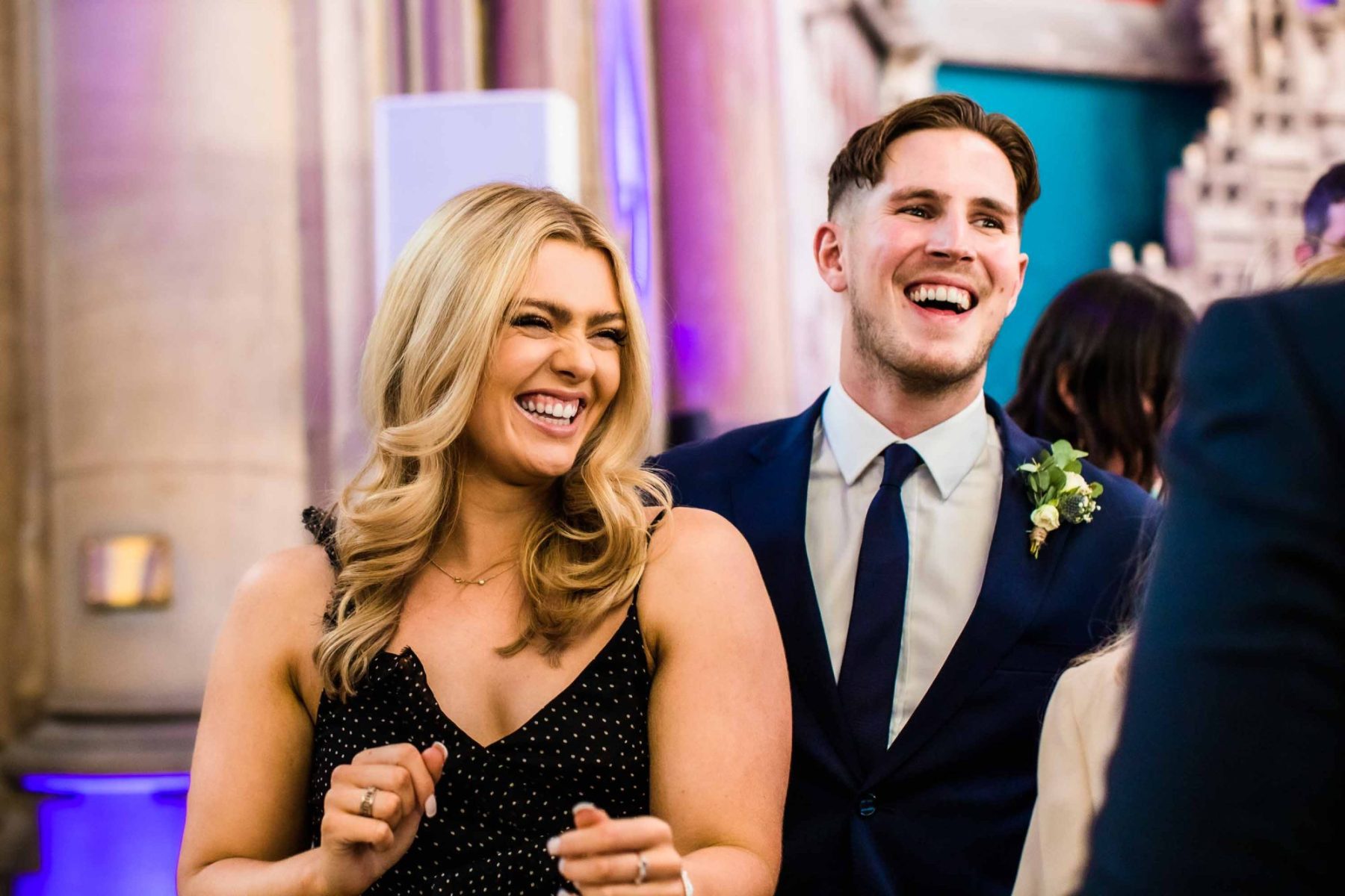 Two wedding guest smiling and dancing